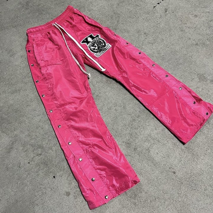 Men's baggy fit nylon sweatpants with windproof design and distressed embroidery detailing, displayed in charcoal grey